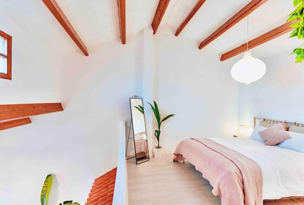 - une chambre avec des murs blancs et un lit avec une couverture rose dans l'établissement UNIQUE LOFT, à Orihuela Costa