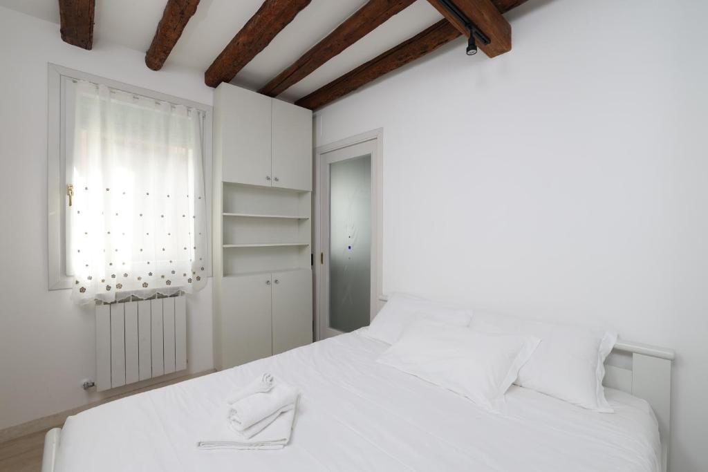 A bed or beds in a room at Ca Giardini Apartments in Biennale by Bricola Apartments
