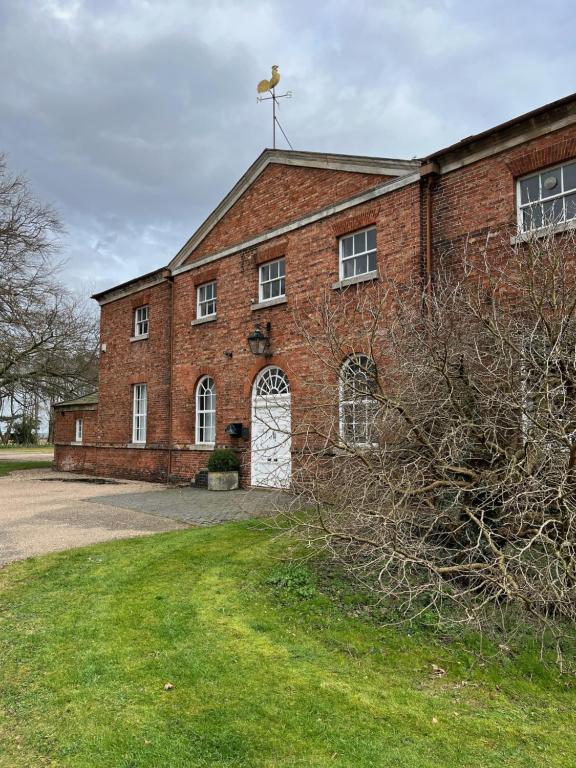 an old red brick building with a white door at The Mulberry Apartment at Langford Hall in Newark-on-Trent