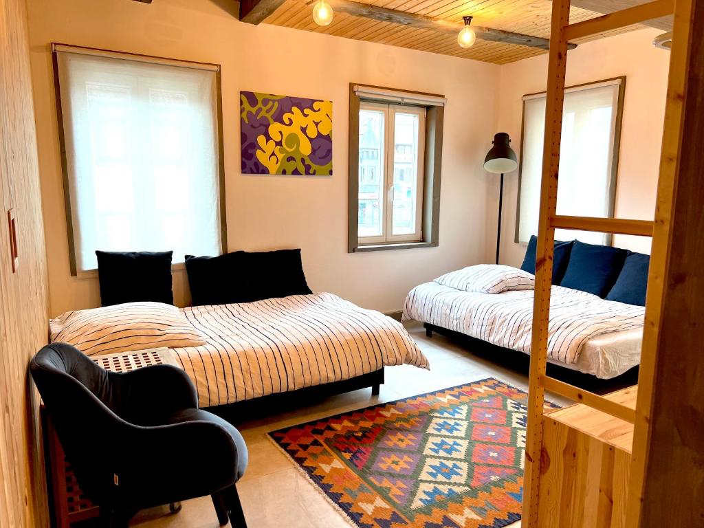 una camera con due letti, una sedia e un tappeto di Blaue Wohnung- Ferienwohnung (Goldenes-Häusle) a Sulzbach an der Murr