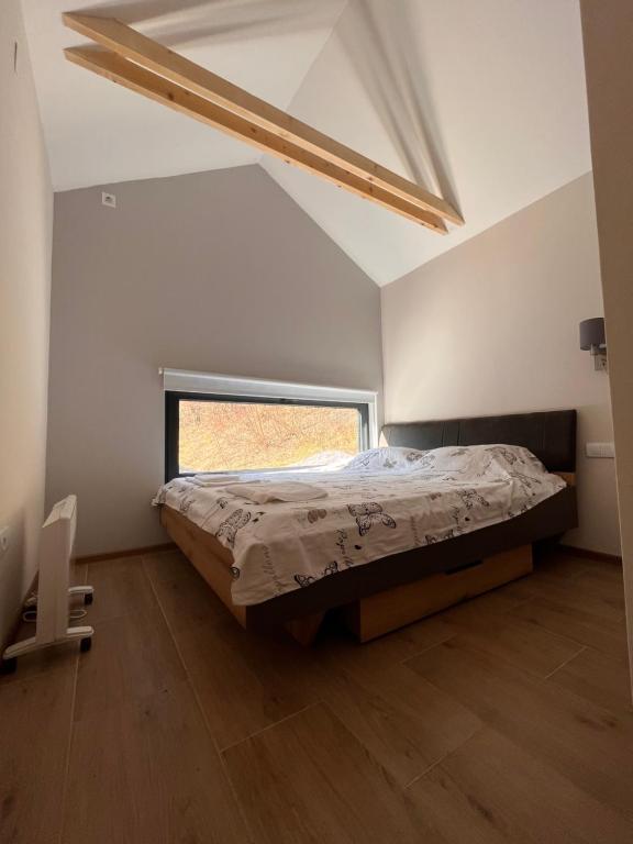 1 dormitorio con 1 cama en una habitación con ventana en Studen Jaz en Kraljevo