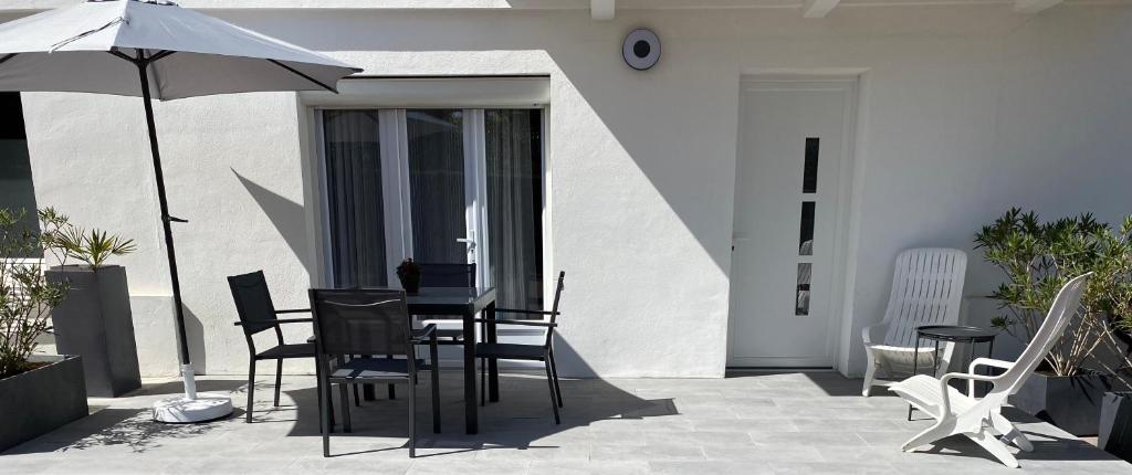 a patio with a table and chairs and an umbrella at ZER GOCHOA in Cambo-les-Bains