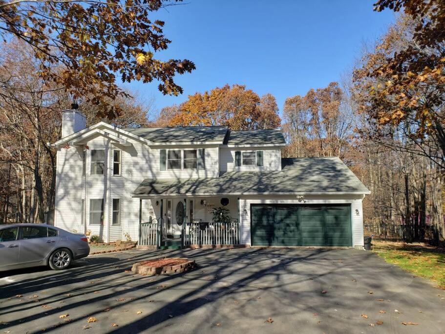 a white house with a car parked in front of it at Fantastic Poconos home w/ Fireplace + More!!! in Long Pond