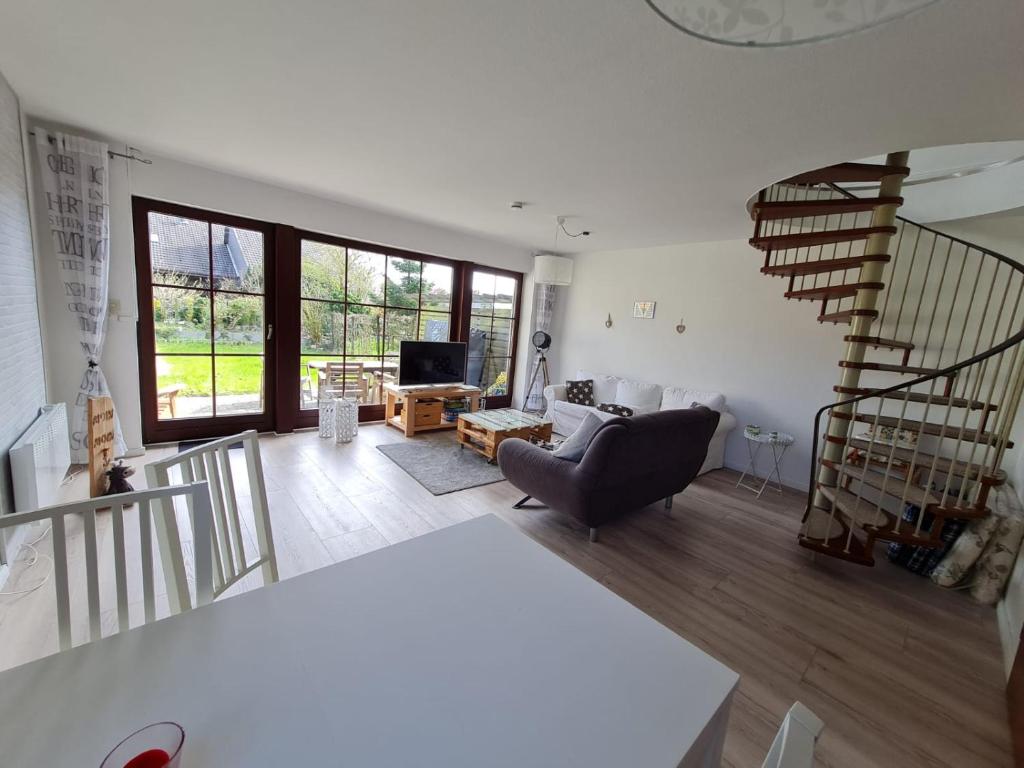 ein Wohnzimmer mit Treppe und Couch in der Unterkunft Ferienhaus Kleine Robbe in Friedrichskoog