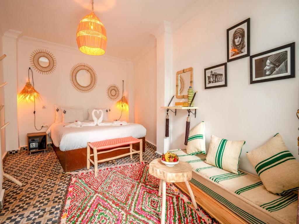 Riad Art & Emotions Boutique Hotel & Spa في مراكش: غرفة معيشة مع سرير وأريكة