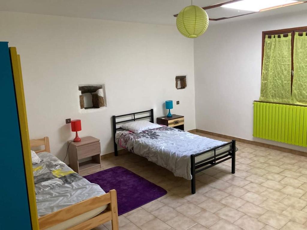 sypialnia z 2 łóżkami i fioletowym dywanem w obiekcie Gîte L'hirondelle w mieście Meyrueis