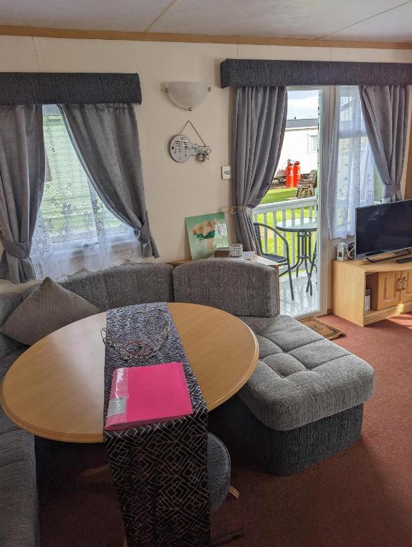 a living room with a table and a couch at The Topaz Caravan HF12 in Ingoldmells