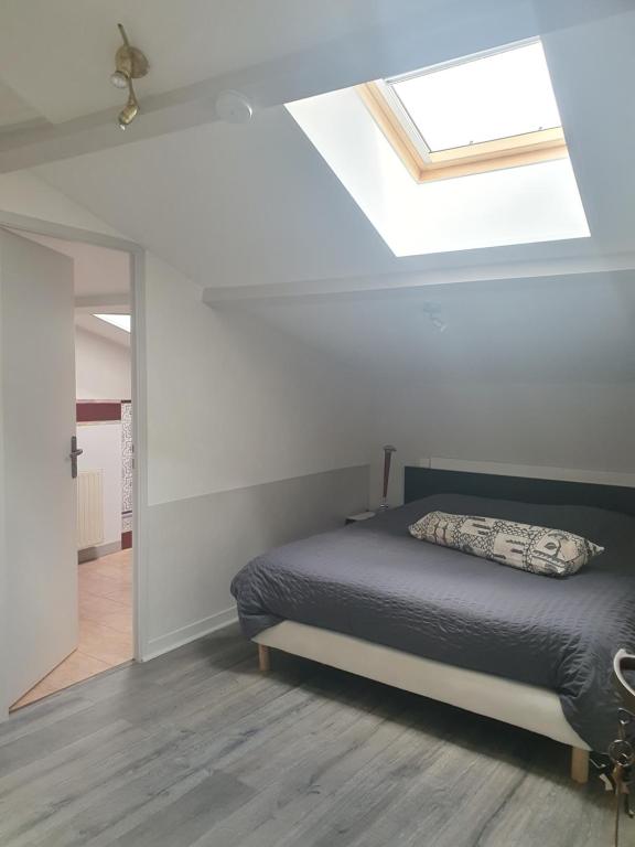 ein Schlafzimmer mit einem Bett und einem Dachfenster in der Unterkunft Le relais de la cure in Saint-Juire-Champgillon