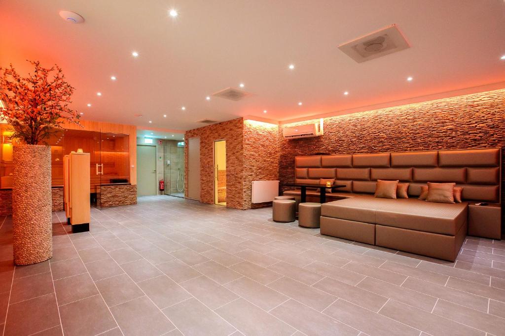 a lobby with a couch and a brick wall at Privé Spa L'amour in Nuenen