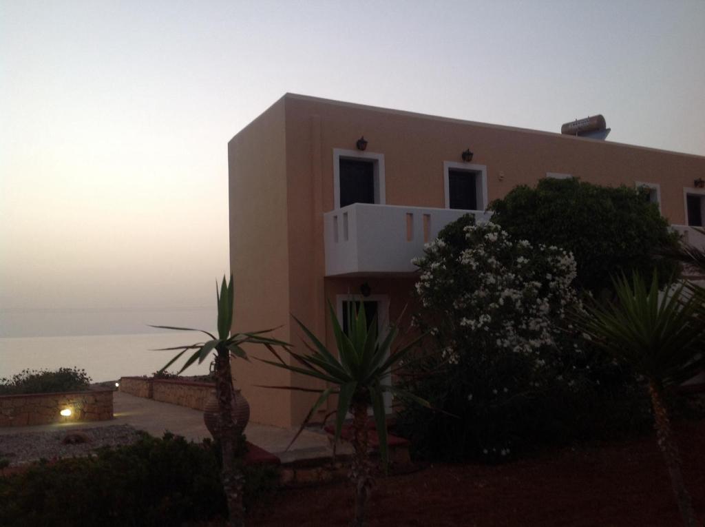 a house with the sunset in the background at Archipelagos Apartments in Arkasa