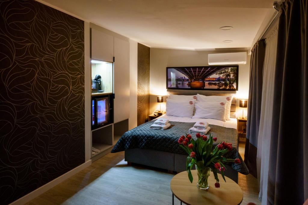 una habitación de hotel con una cama y una mesa con flores en Kamienica no 111a en Varsovia