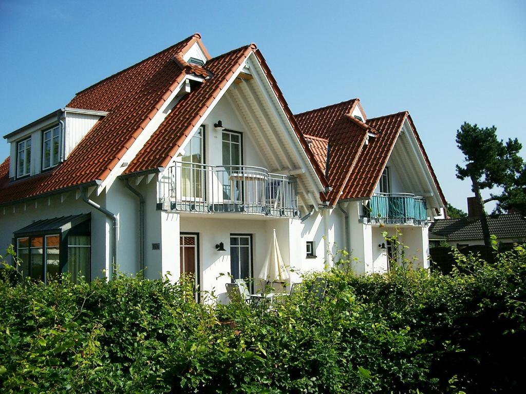 ein großes weißes Haus mit rotem Dach in der Unterkunft Ferienwohnung Seestern in Vitte