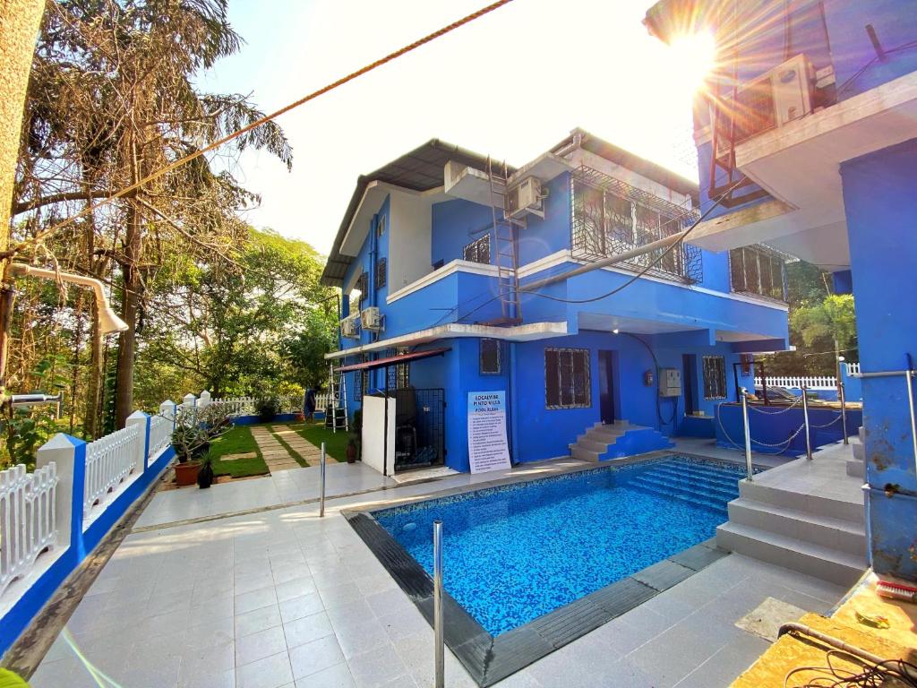 a blue house with a swimming pool in front of it at Pinto Holiday Villas in Sangolda