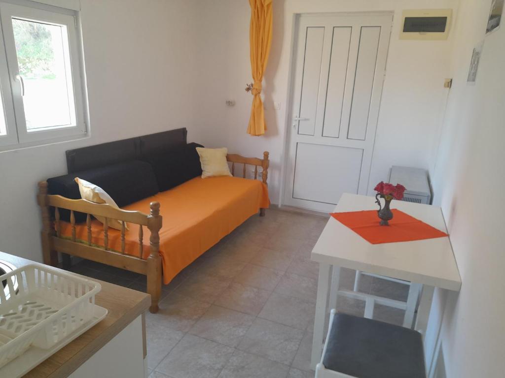 ein kleines Schlafzimmer mit einem Bett und einem Tisch in der Unterkunft Gospava Apartman in Igalo