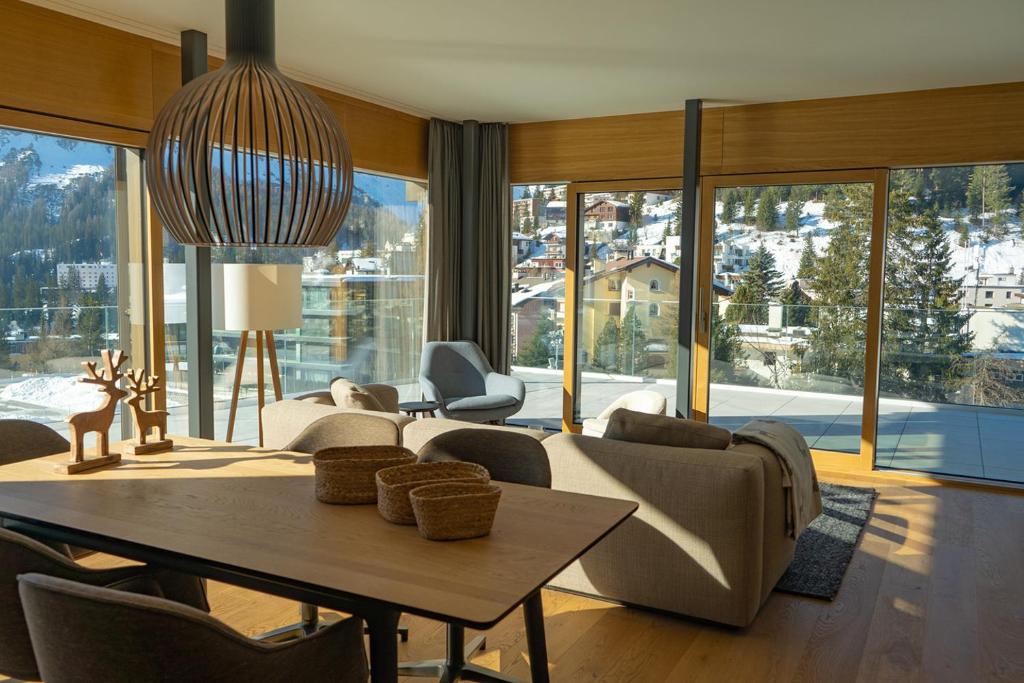 a living room with a table and chairs and a large window at sunrise2sunset in Arosa