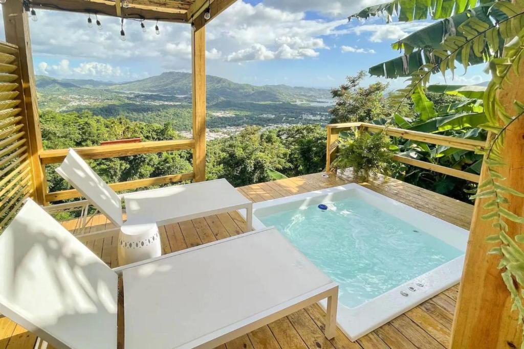 uma banheira de hidromassagem no deque de uma casa em Villa Vacacional en Puerto Rico para parejas em Villalba