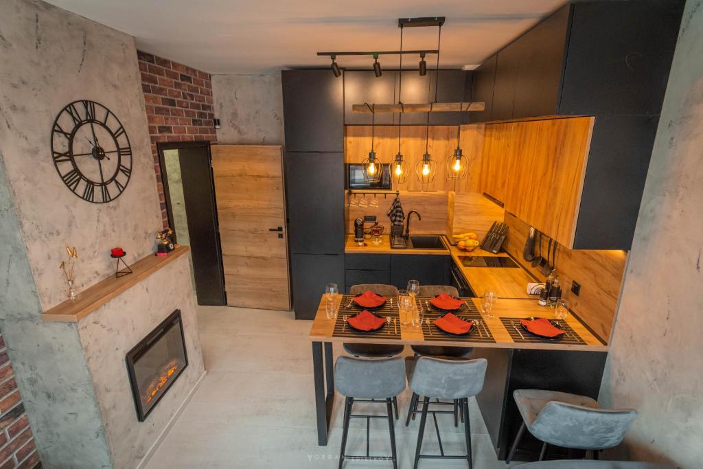 a kitchen with a table and chairs and a clock at Da Vinci Apartment in Vratsa