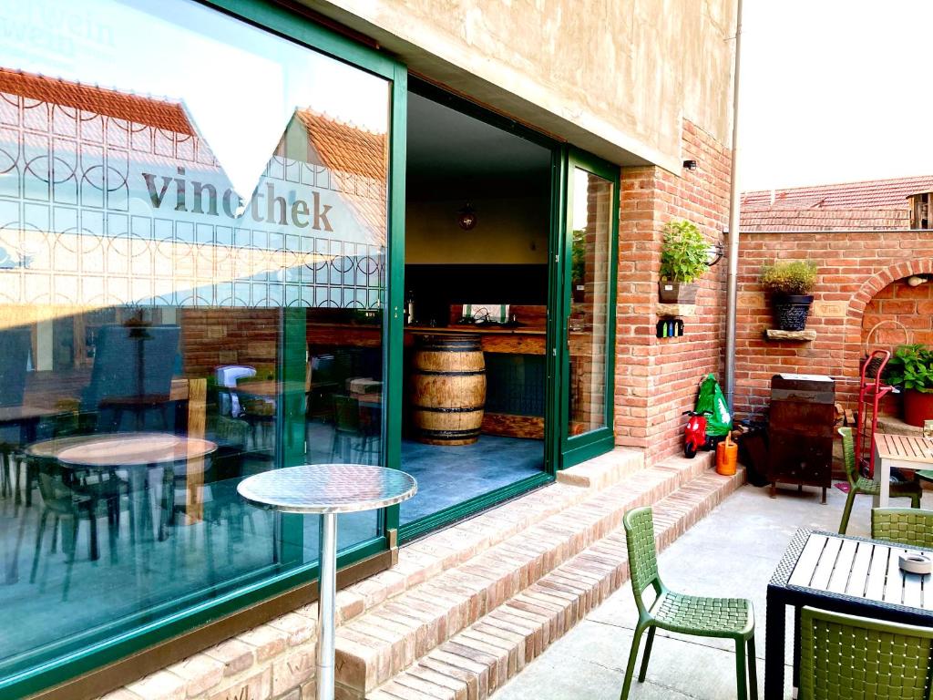 a wine shop with tables and chairs in a window at Penzion Za radnicí in Valtice