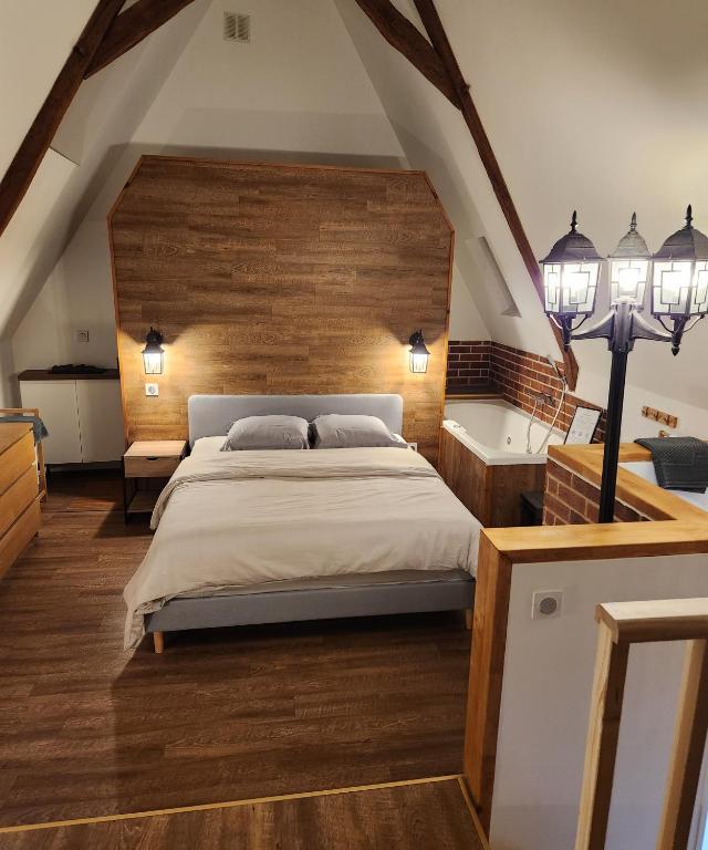 ein Schlafzimmer mit einem großen Bett und zwei Leuchten in der Unterkunft Duplex cosy Life Balnéo in Cysoing