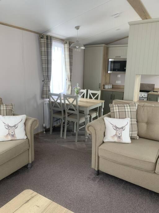 uma sala de estar com 2 sofás e uma sala de jantar em Grasmere Lodge Unit 31 em Carlisle