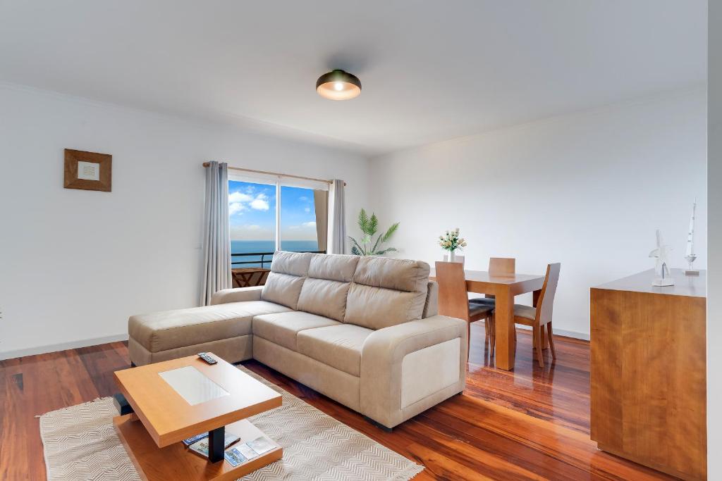 un soggiorno con divano e tavolo di Santa Cruz Apartment with Sea View by HR Madeira a Santa Cruz