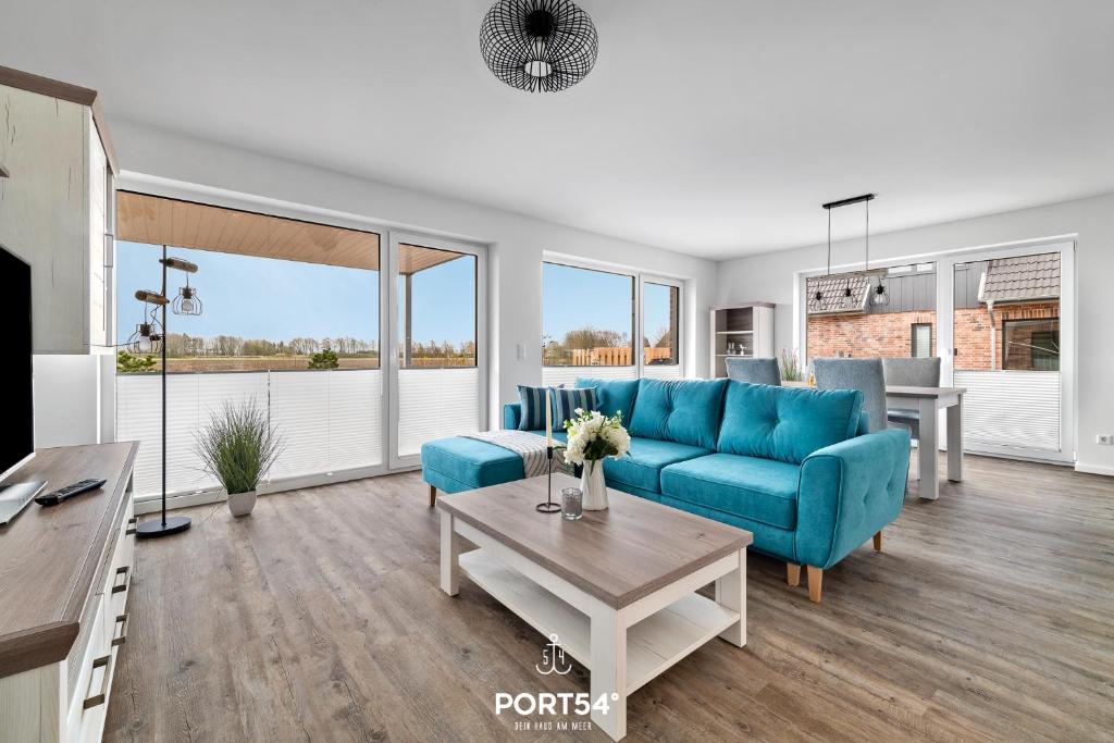 a living room with a blue couch and a table at Küste 1 in Büsum