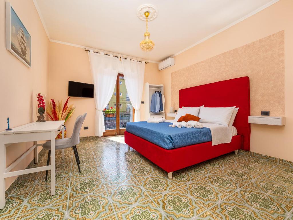 Schlafzimmer mit einem roten Bett und einem Schreibtisch in der Unterkunft La Rosa Home Sorrento coast in Piano di Sorrento