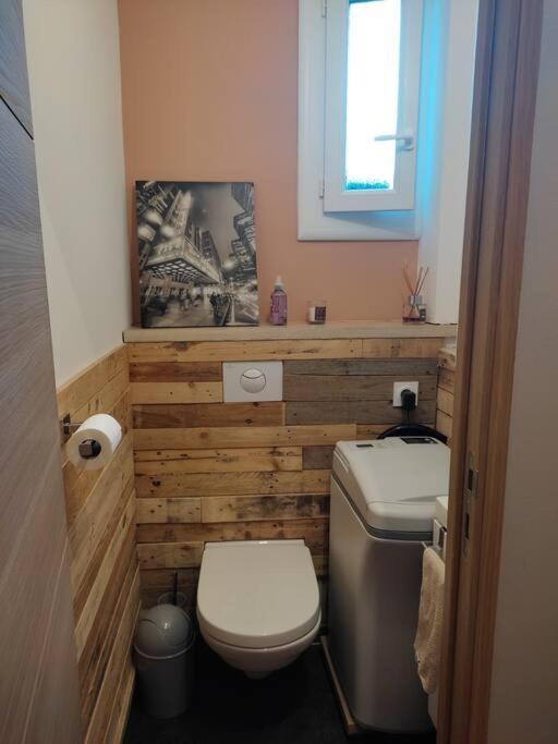 a small bathroom with a toilet and a window at Appartement de 55m2 climatisé à 6 min du tram in Marseille