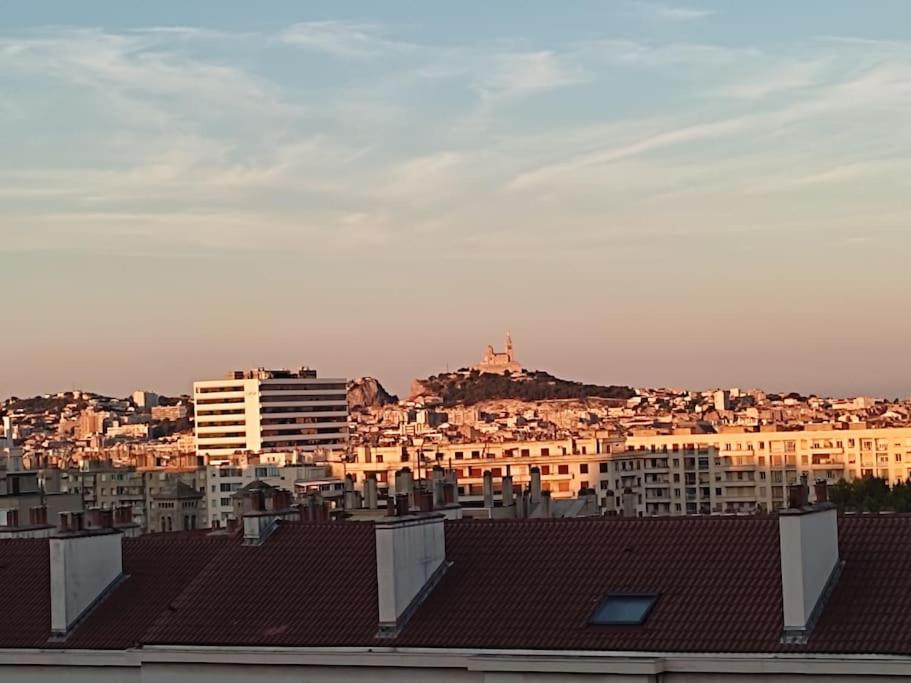 a city with buildings and a hill in the background at Appartement de 55m2 climatisé à 6 min du tram in Marseille