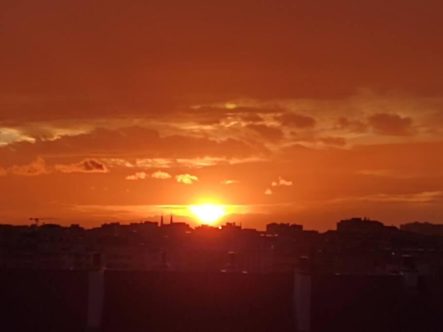 a sunset over a city with the sun setting at Appartement de 55m2 climatisé à 6 min du tram in Marseille