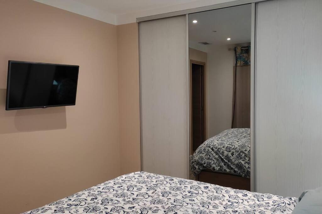 a bedroom with two beds and a tv on the wall at Appartement de 55m2 climatisé à 6 min du tram in Marseille