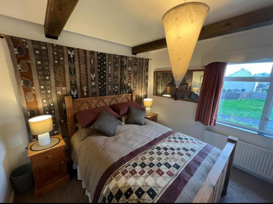 a bedroom with a large bed and a window at Cosy private accommodation in Corsham, near Bath in Corsham