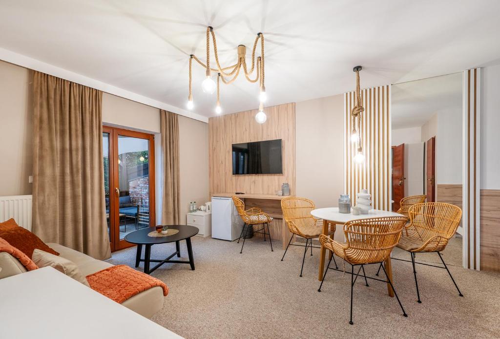 a living room with a couch and a table and chairs at Akacjowa Zatoka - Pokoje i Apartamenty in Mielenko