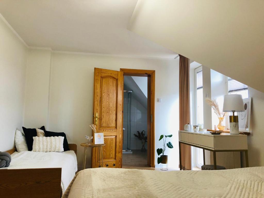 オストシツェにあるPokoje agroturystyczne U Haniのベッドルーム1室(ベッド2台付)、バスルームへのドアが備わります。