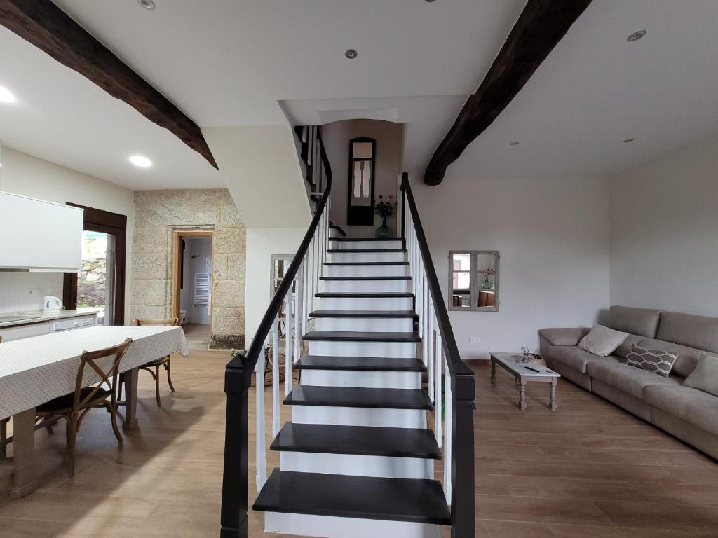 eine Treppe in einem Wohnzimmer mit Sofa und Tisch in der Unterkunft Casa do Porto 