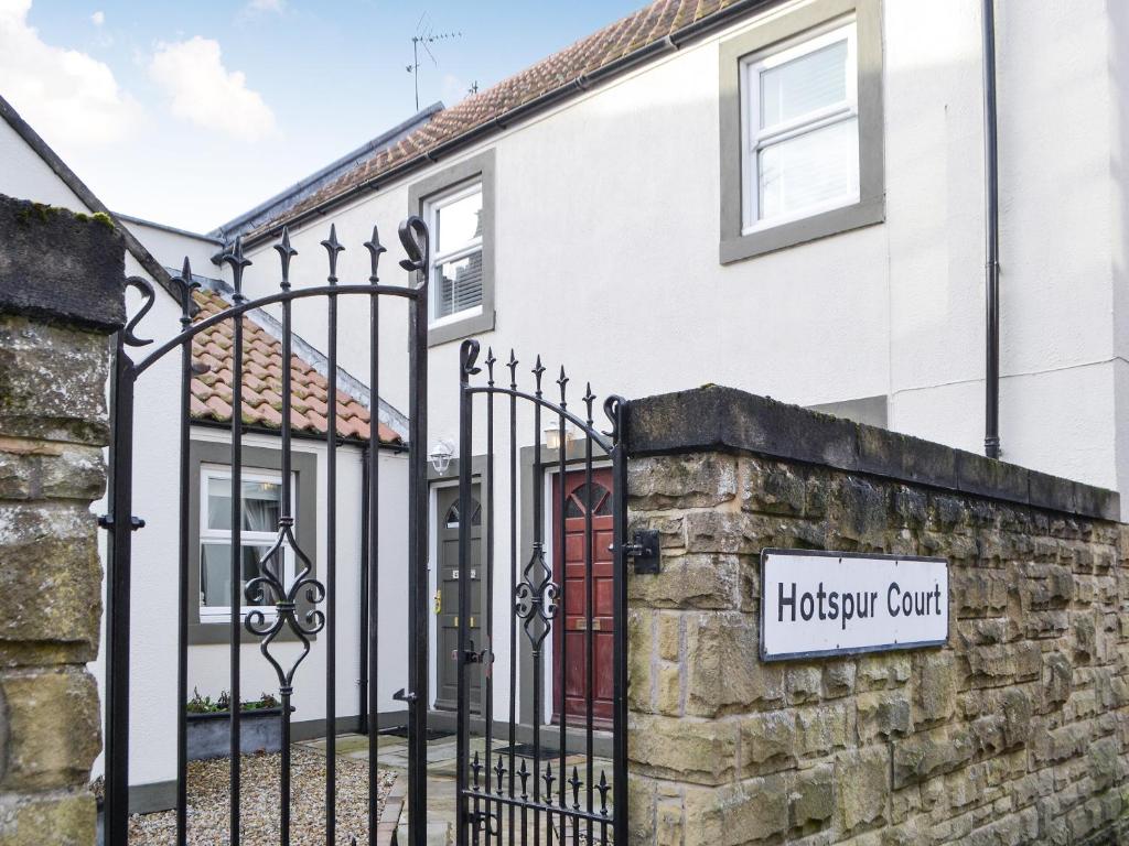 a house with a gate and a sign that reads hogwarts court at The Loft in Warkworth