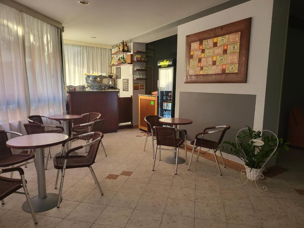 a restaurant with tables and chairs and a kitchen at Hotel Giovanna in Montecatini Terme