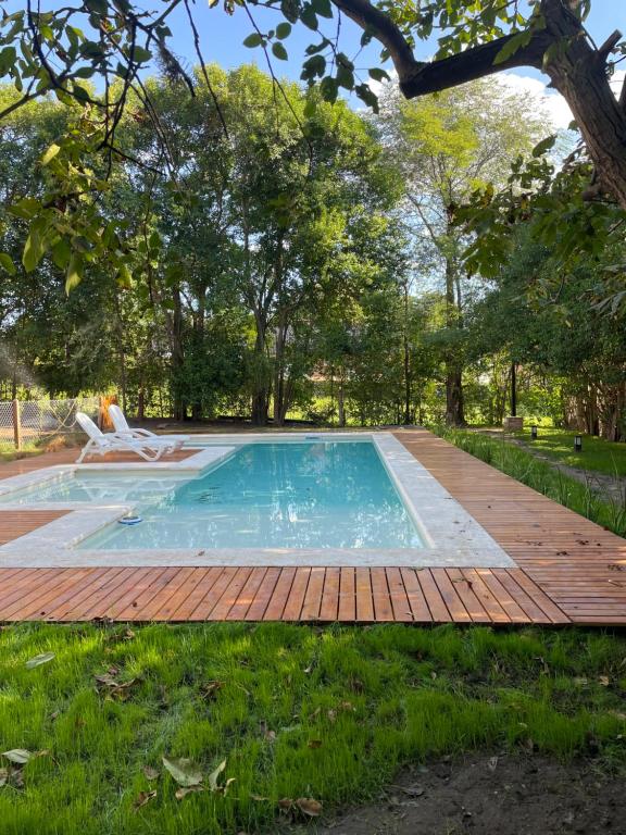 a swimming pool with a wooden deck and a swimming poolvisor at La Franca Aparts in Villa General Belgrano