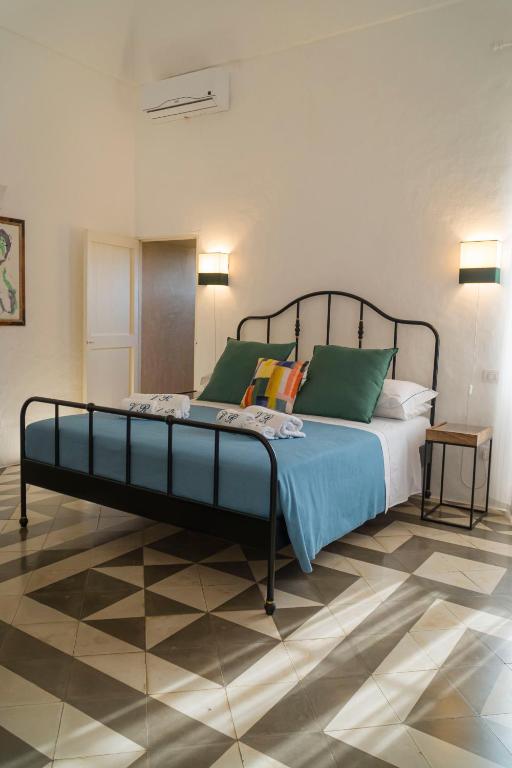a bedroom with a large bed with green pillows at Villa Romasi in Leuca