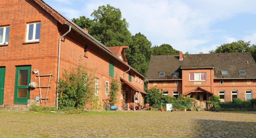 um grupo de edifícios de tijolos num quintal em Ferienwohnung Bioland-Hof Wilkens em Visselhövede