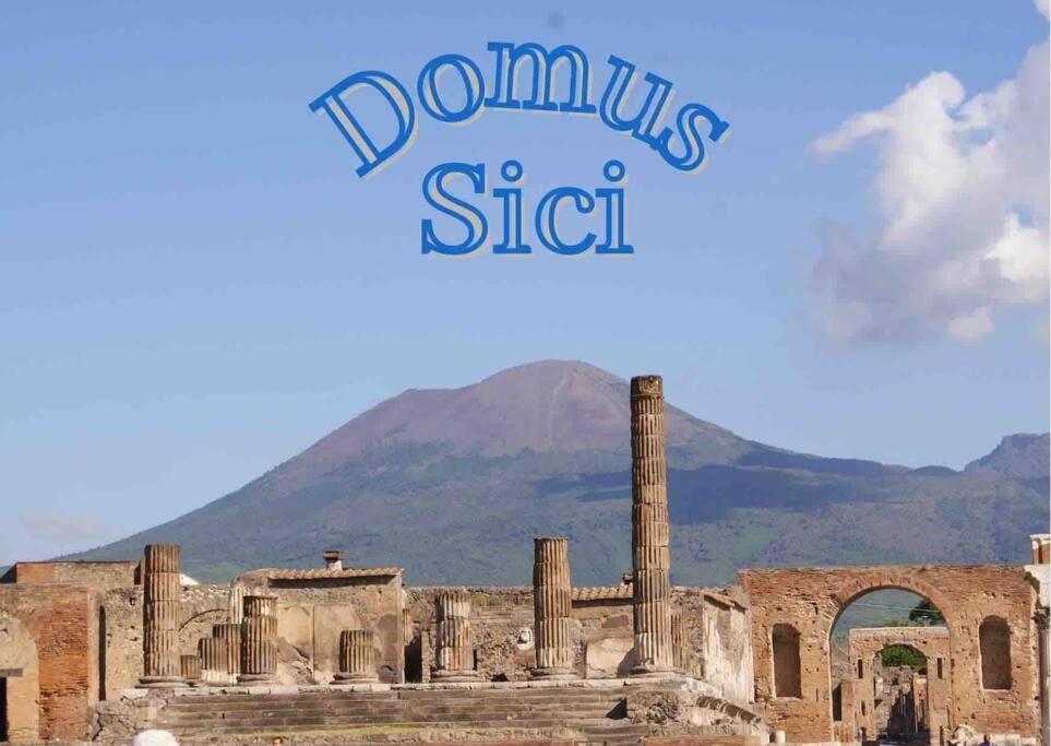 an image of the ruins of a building with a mountain in the background at Domus Sici in Pompei
