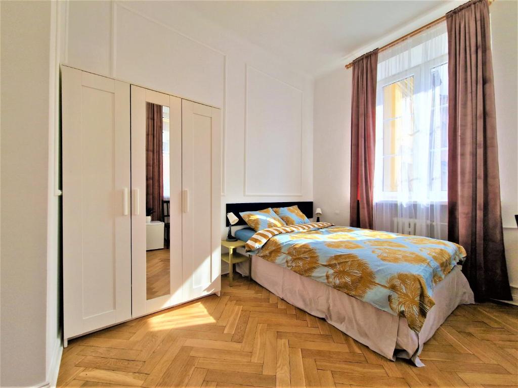 a bedroom with a bed and a window at J&W Apartments Świętojańska Rooms in Warsaw