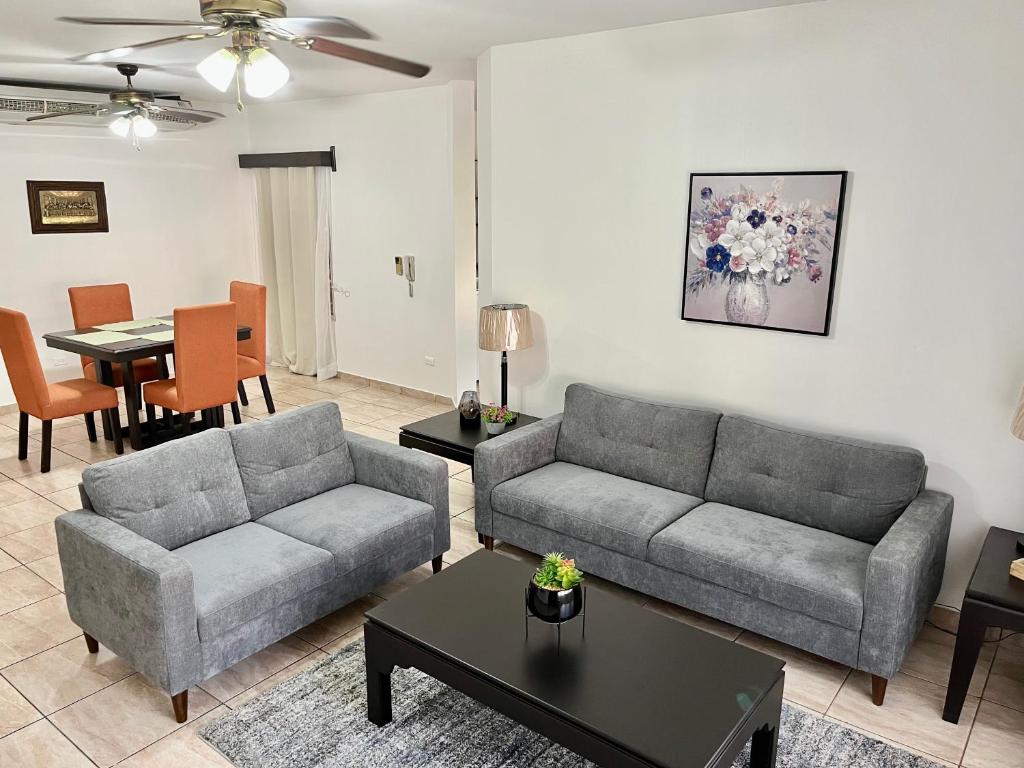 a living room with two couches and a table at Apartamentos Villas del Sol in San Pedro Sula