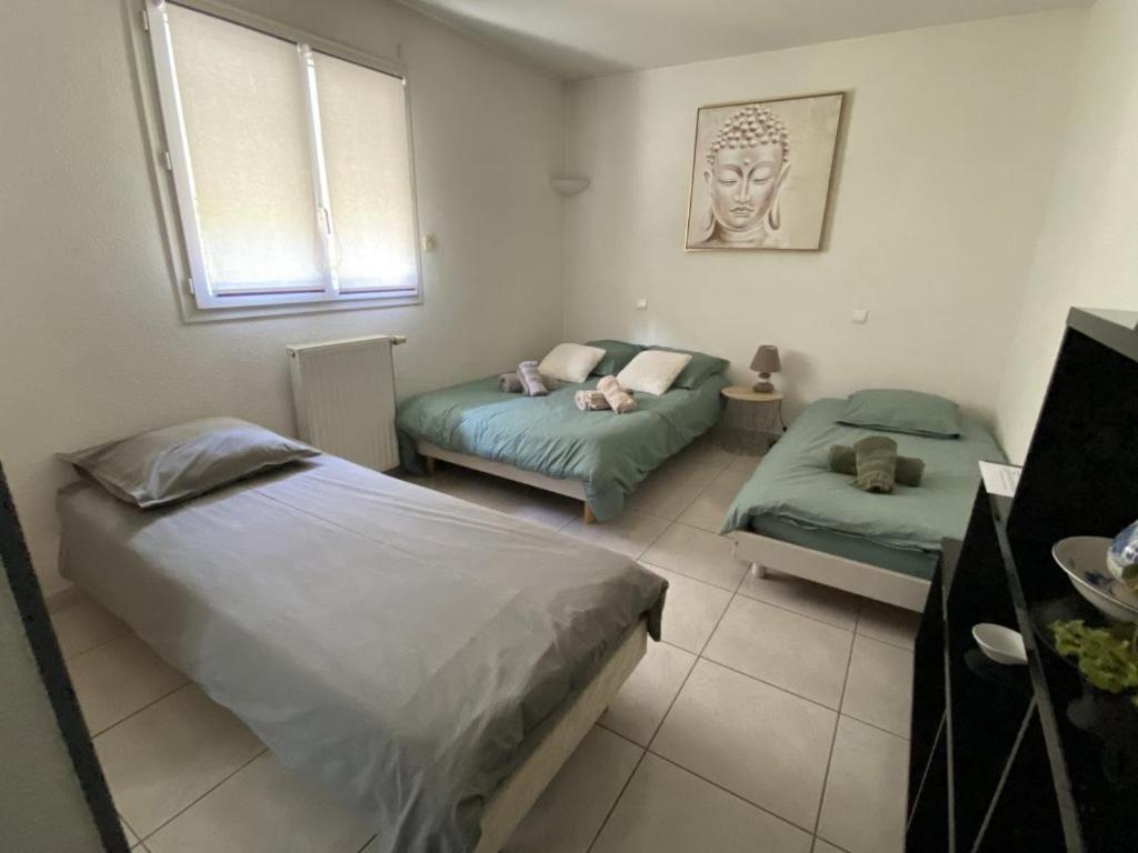 um quarto com 2 camas, um sofá e uma janela em L'instant d'un séjour em Le Guâ