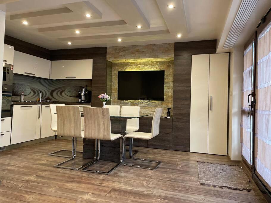 eine Küche mit einem Tisch und Stühlen sowie einem TV in der Unterkunft Brand New Valera Luxury Studio in Warna