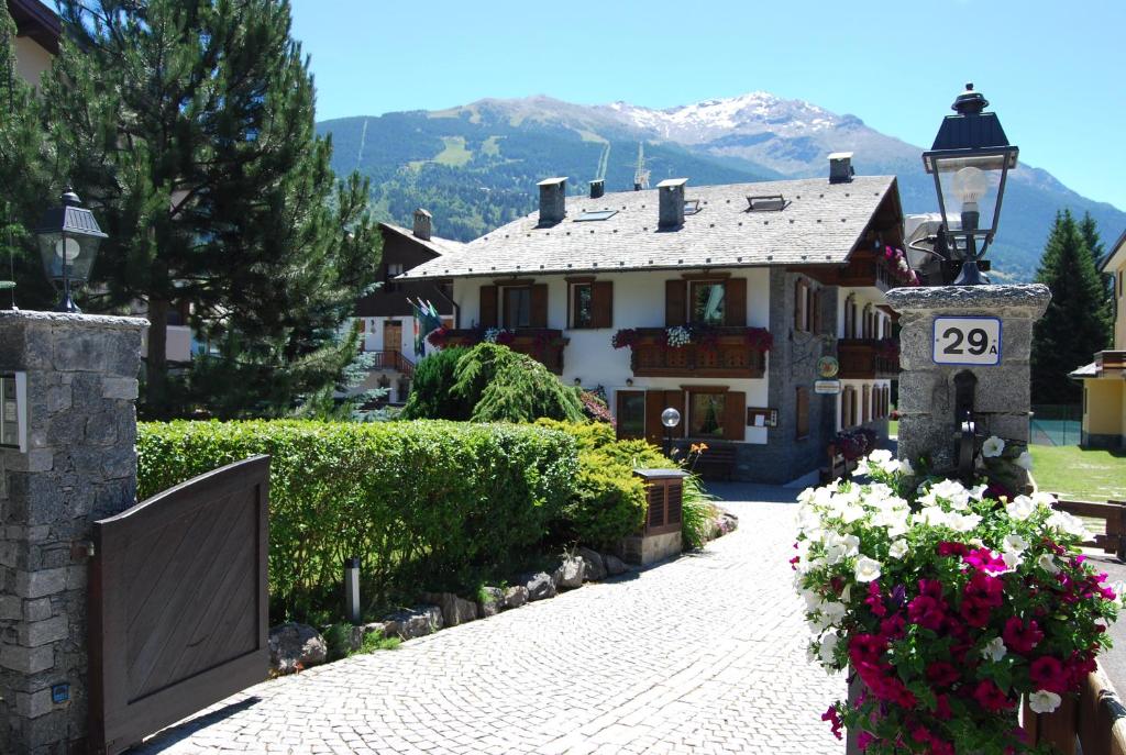 ボルミオにあるChalet Gardeniaの門と花の前の家