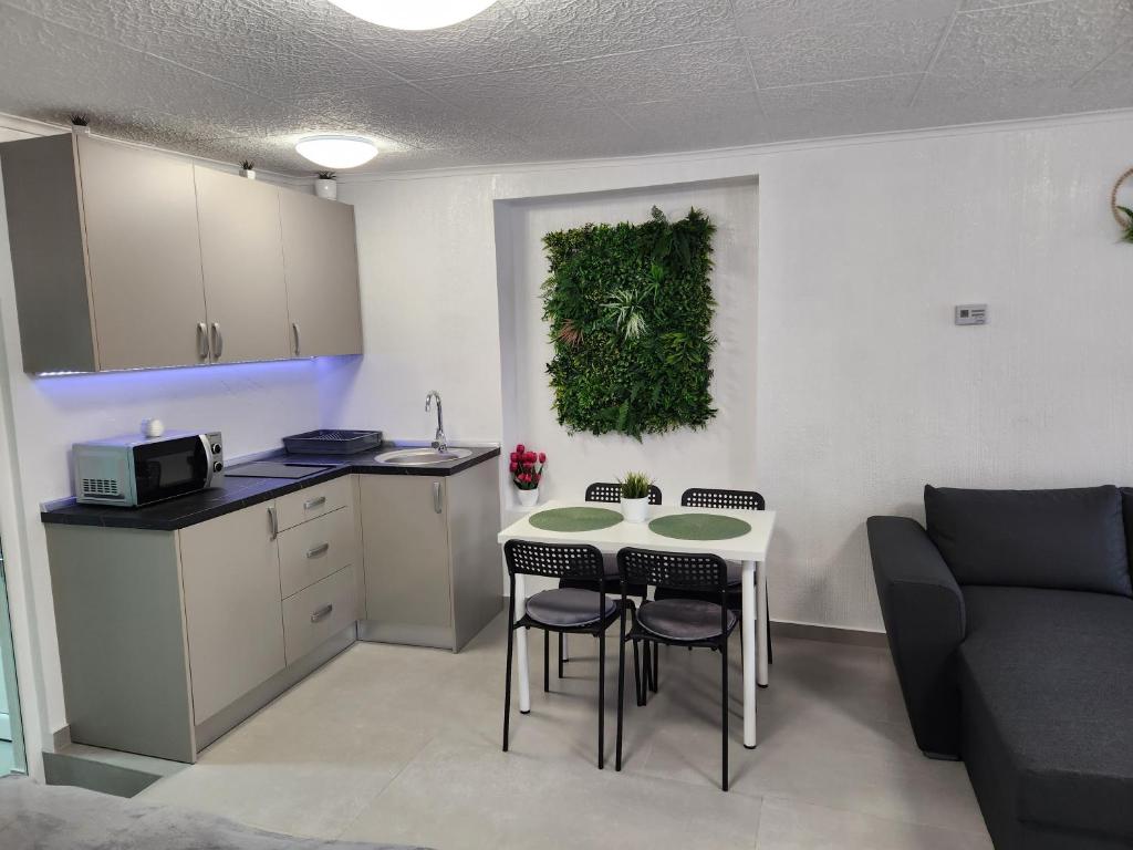 Una cocina y una sala de estar con mesa y sillas. en Apartament DADA, en Sighişoara