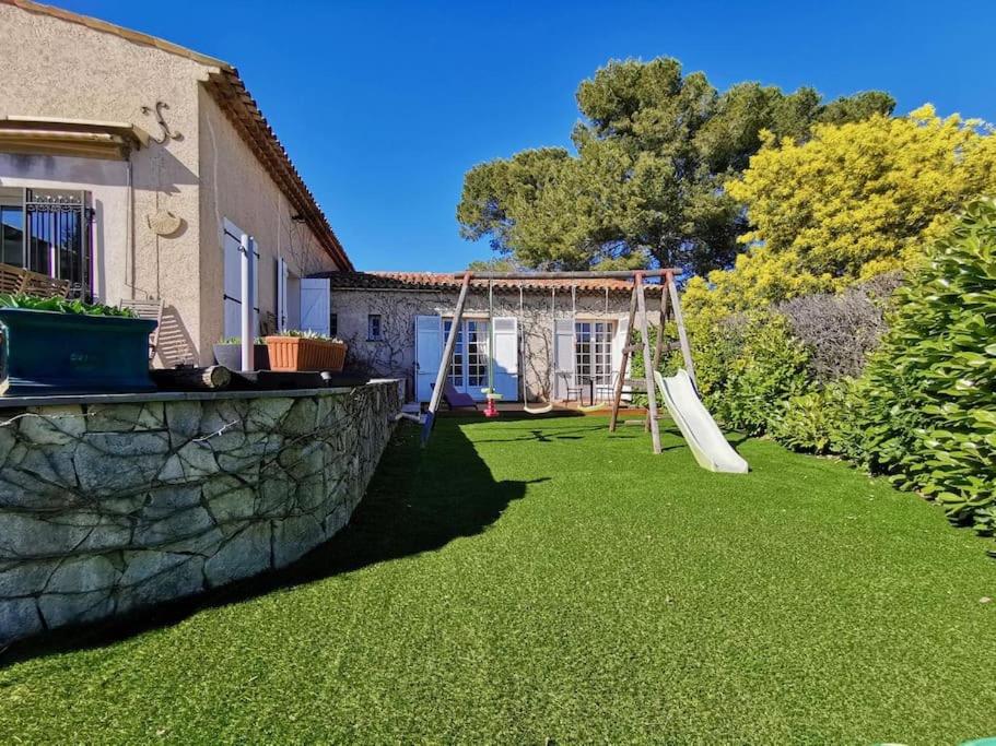 a backyard with a swing set on the grass at Beautiful Sea View House in Vallauris