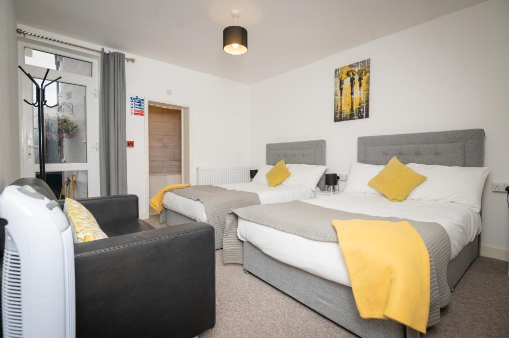 una camera con due letti e un divano di Immaculate Apartment meters from the beach a Great Yarmouth