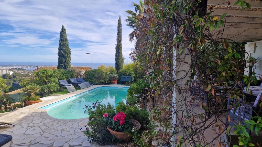 a swimming pool with plants on the side of a building at Beautiful Sea View House in Vallauris